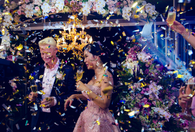 The bride and groom are surrounded by confetti at their wedding ceremony at their destination wedding in Vietnam.