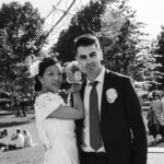 The bride and groom pose for a portrait in front of the London Eye.