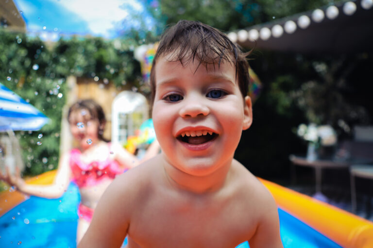 Summer children's portrait in a paddling pool