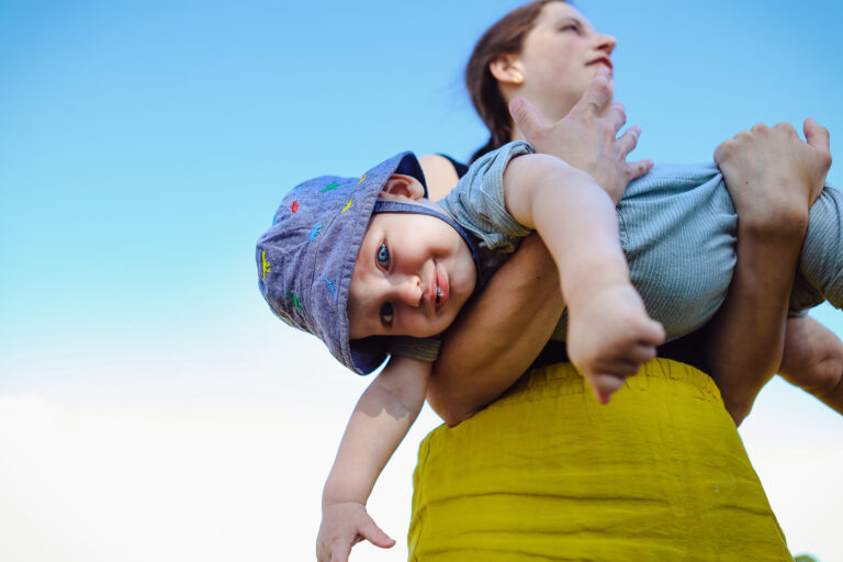 A baby being held upside down by his mum during a play session