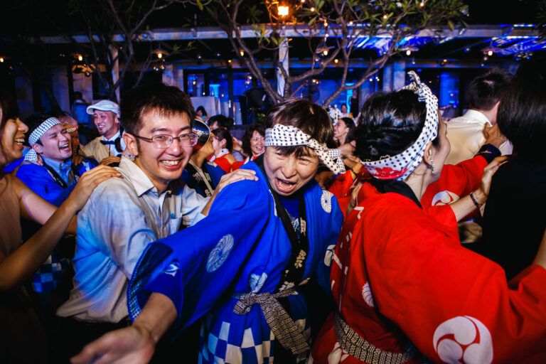 Woman shouting and pointing in conga line at a wedding reception.