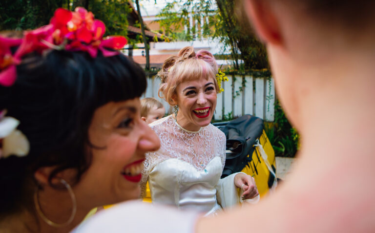 Bride smiling and laughing with bridesmaid before heading to her wedding.