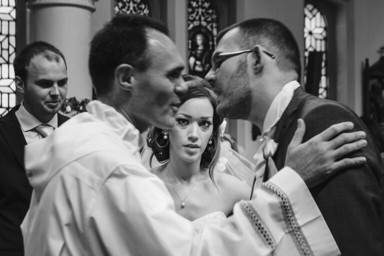 Bride watching the groom greeting the priest at their church wedding in London.