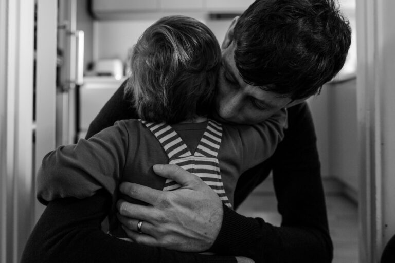 Dad hugging toddler son during a family photo session