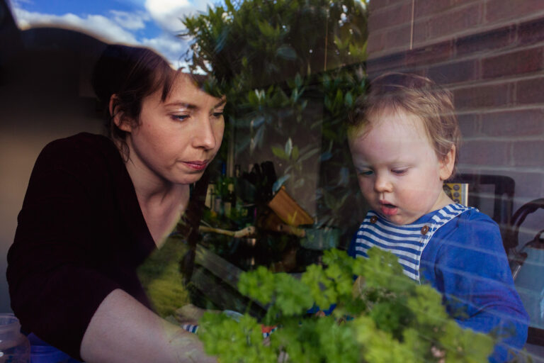 Mum and toddler through kitchen window during a family photo session
