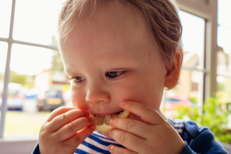Toddler eating a slice of lemon during a family photo session