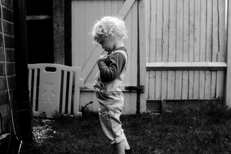 A young boy standing in a garden during a family photo session