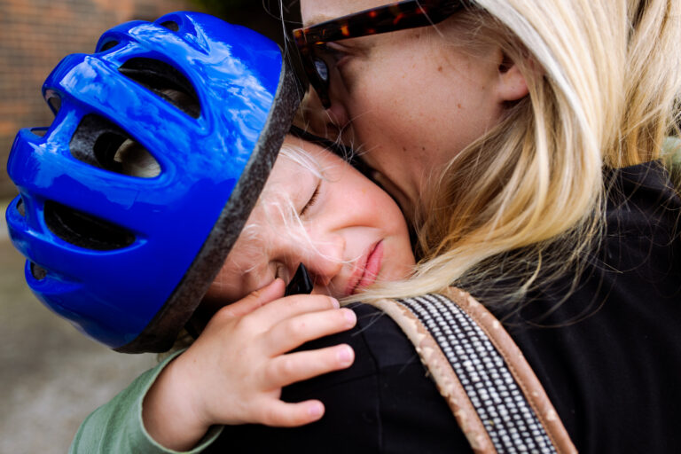 Mum holding her crying son during a family photo session