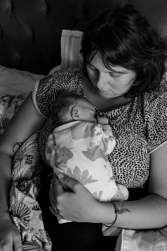 portrait of mother and baby sleeping on her chest