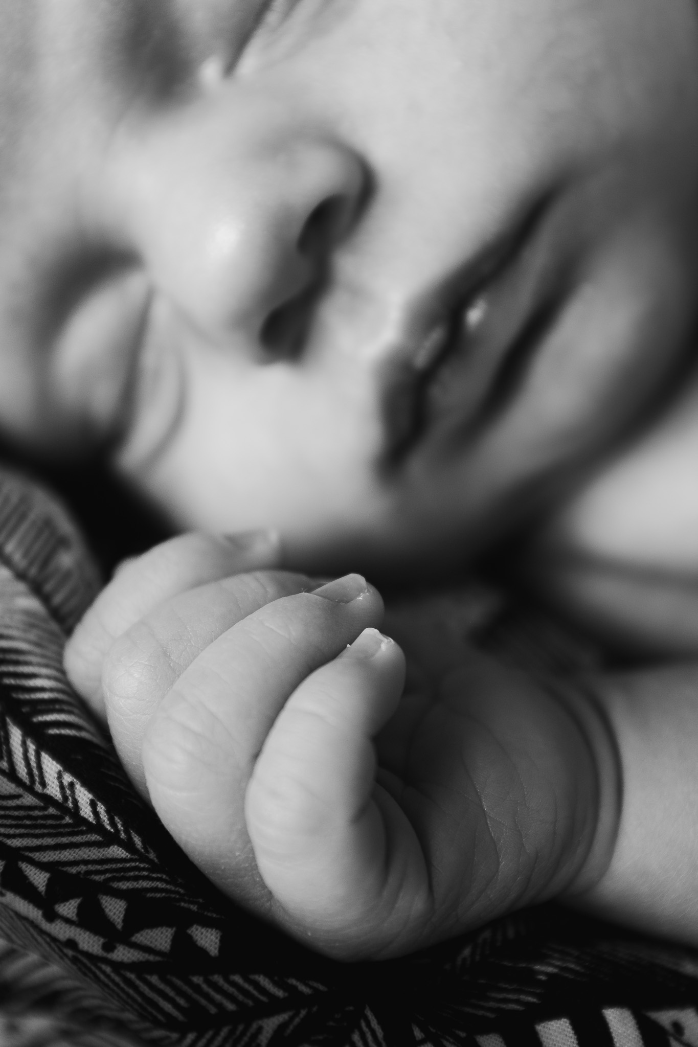 portrait of baby sleeping with hand out in front of it's face