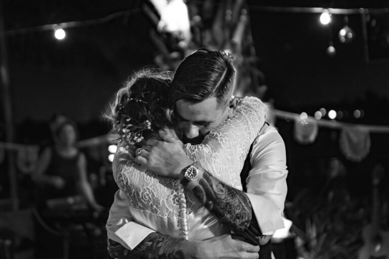 Groom embraces the bride during their first dance.