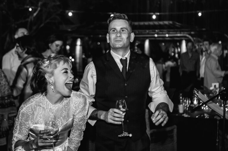 Bride and groom dancing and laughing at their wedding reception.