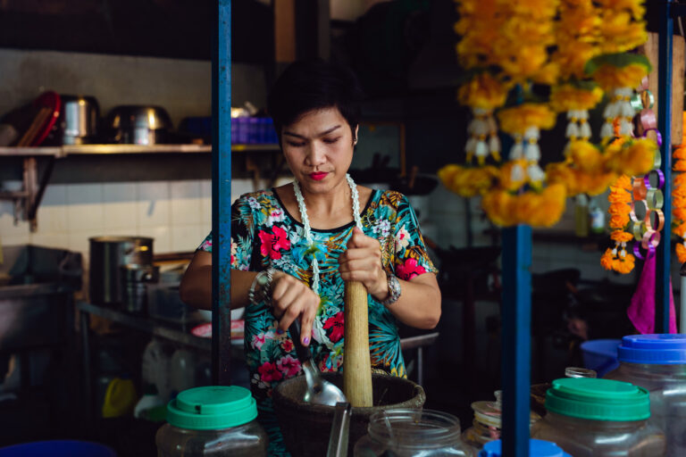 Female chef caught in a candid portrait whilst prepping food at her restaurant in Ho Chi Minh