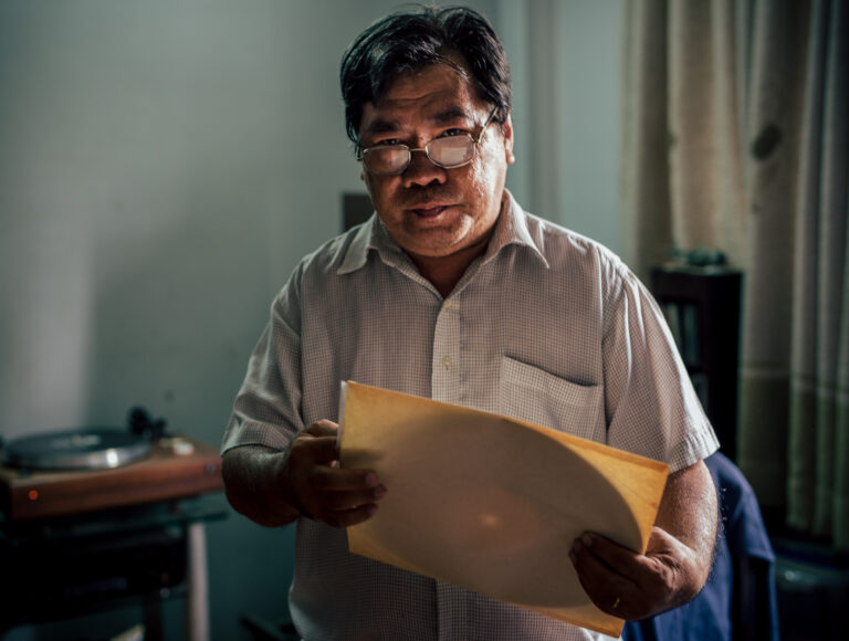A Vietnamese man wearing glasses and holding a vinyl record for an editorial feature in Word Magazine