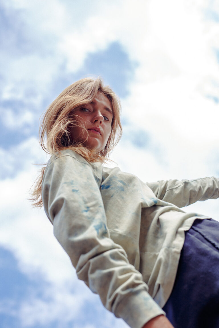 a young woman looks down and poses for a fashion portrait for Fast Women