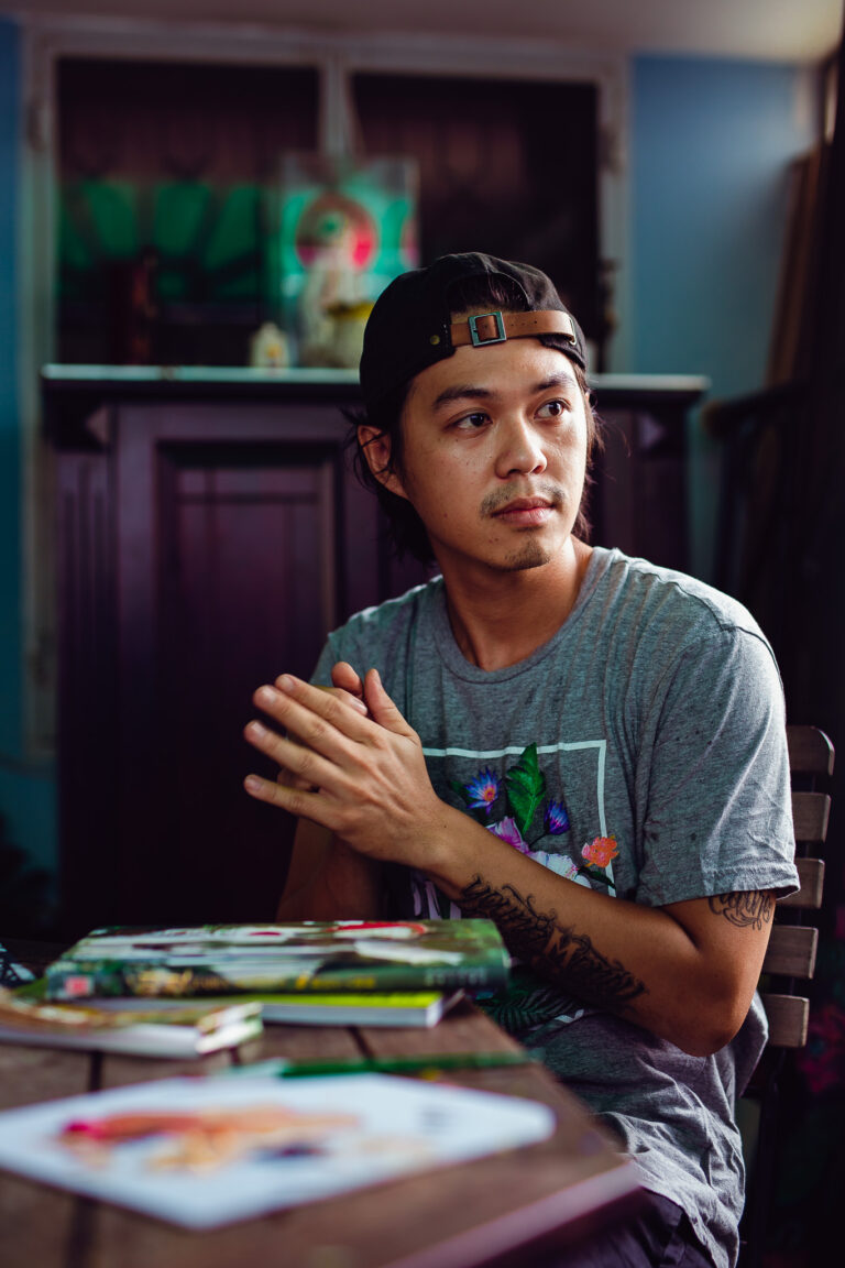 A young Vietnamese artist poses for a portrait whilst sitting in his art studio in Ho Chi Minh