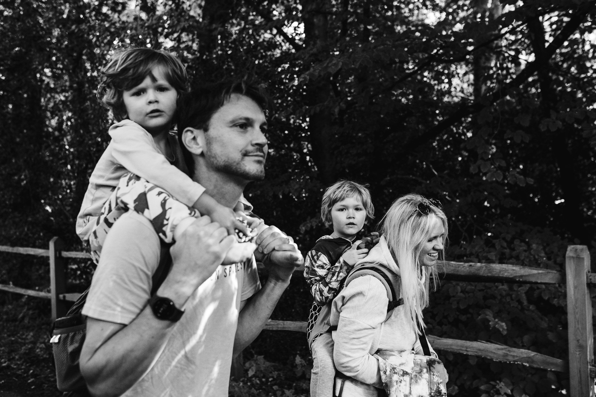 Mum and dad carrying two young sons on their backs during a family photo session.