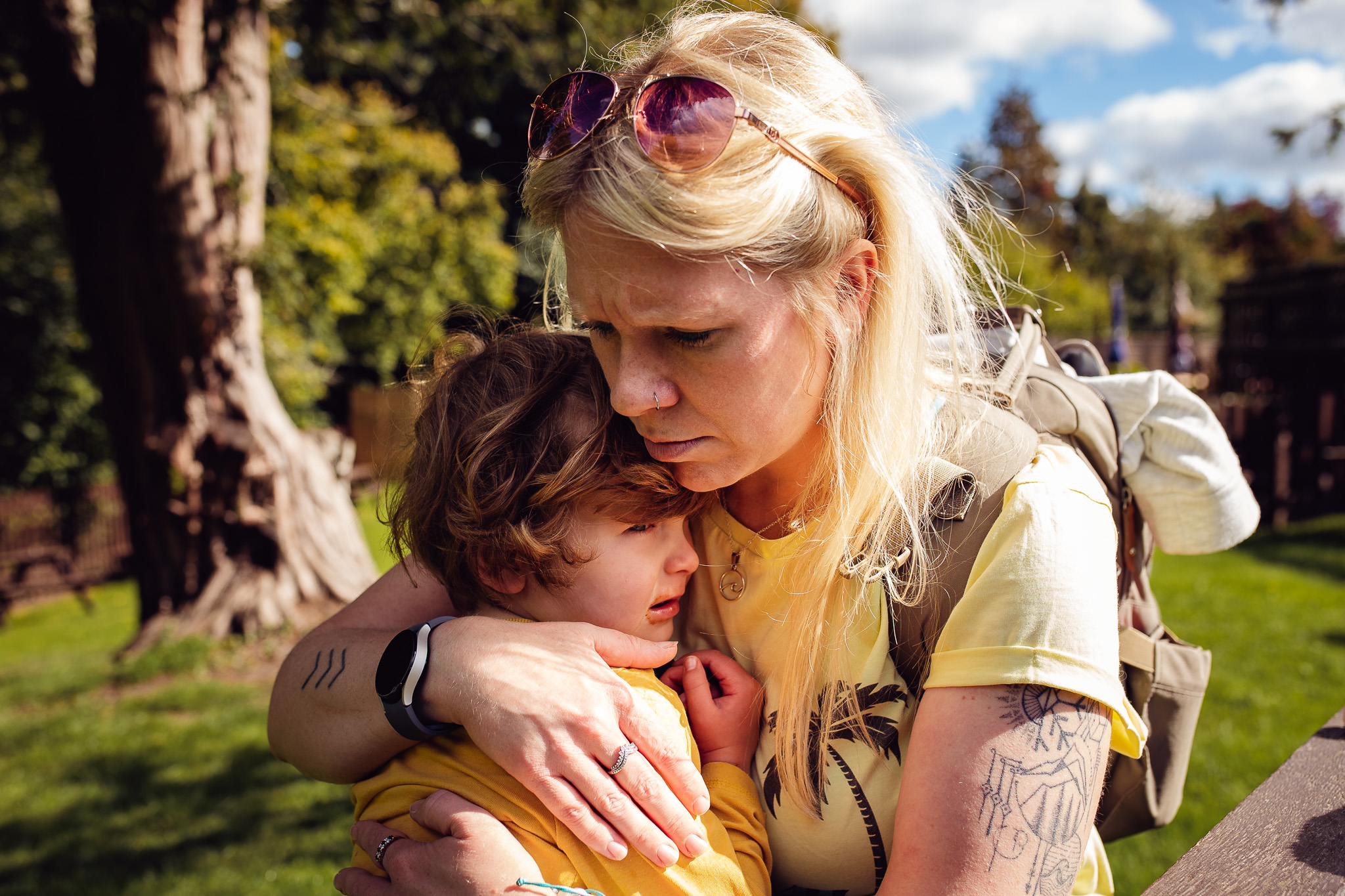 Mum holding and cuddling her crying son during a family photo session.