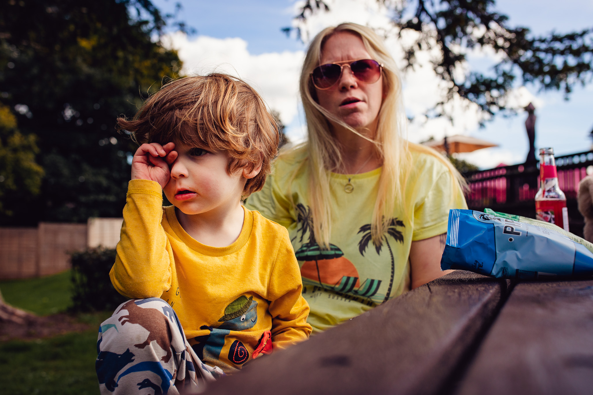 Mum and young son at a picnic table in a pub garden during a family photo session.