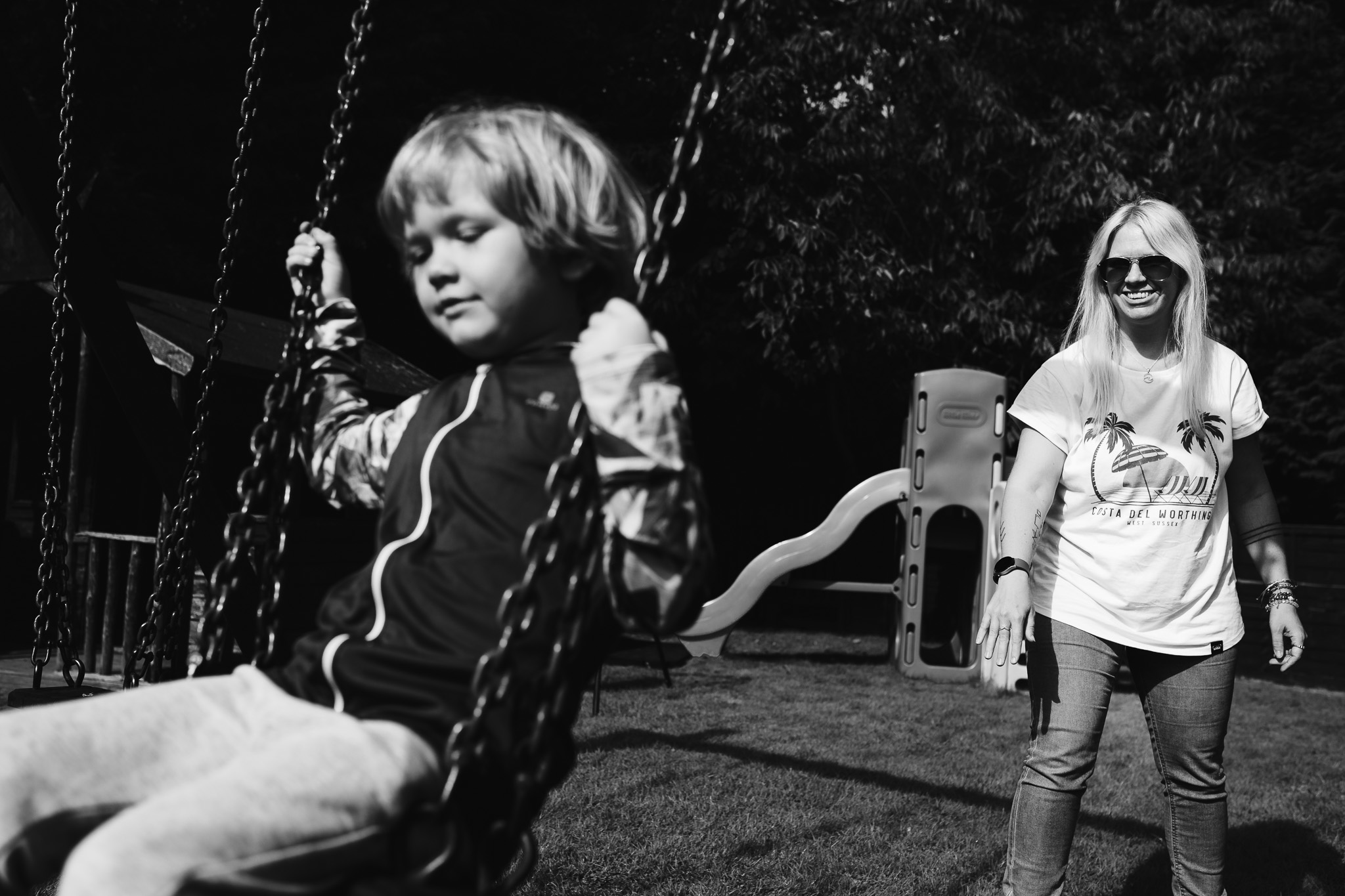 Mum pushing a young boy on a swing during a family photo session.