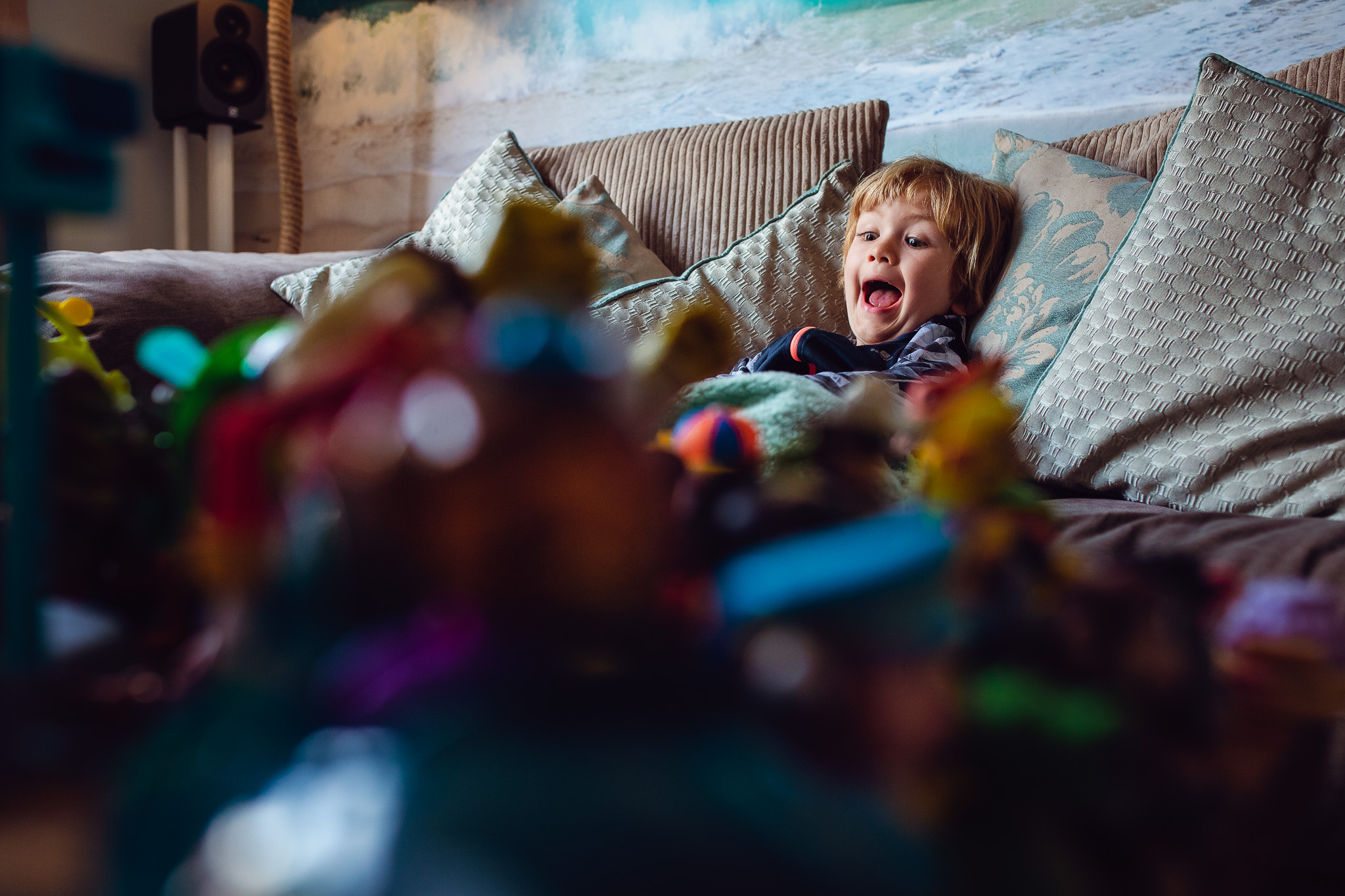 Kai sitting on the sofa and shouting during a family photo session.