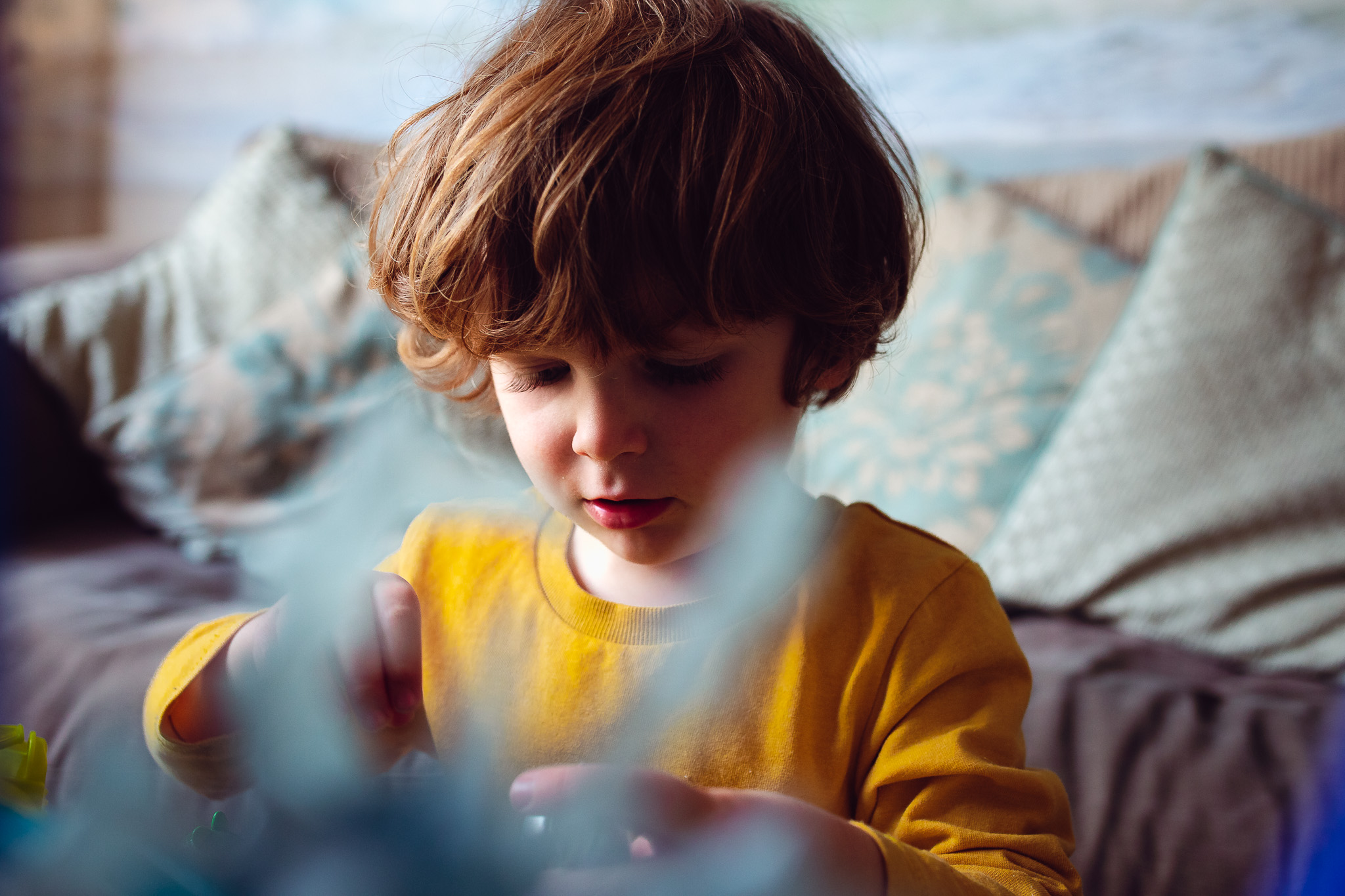 Leo concentrates and plays with his toys during a family photo session.