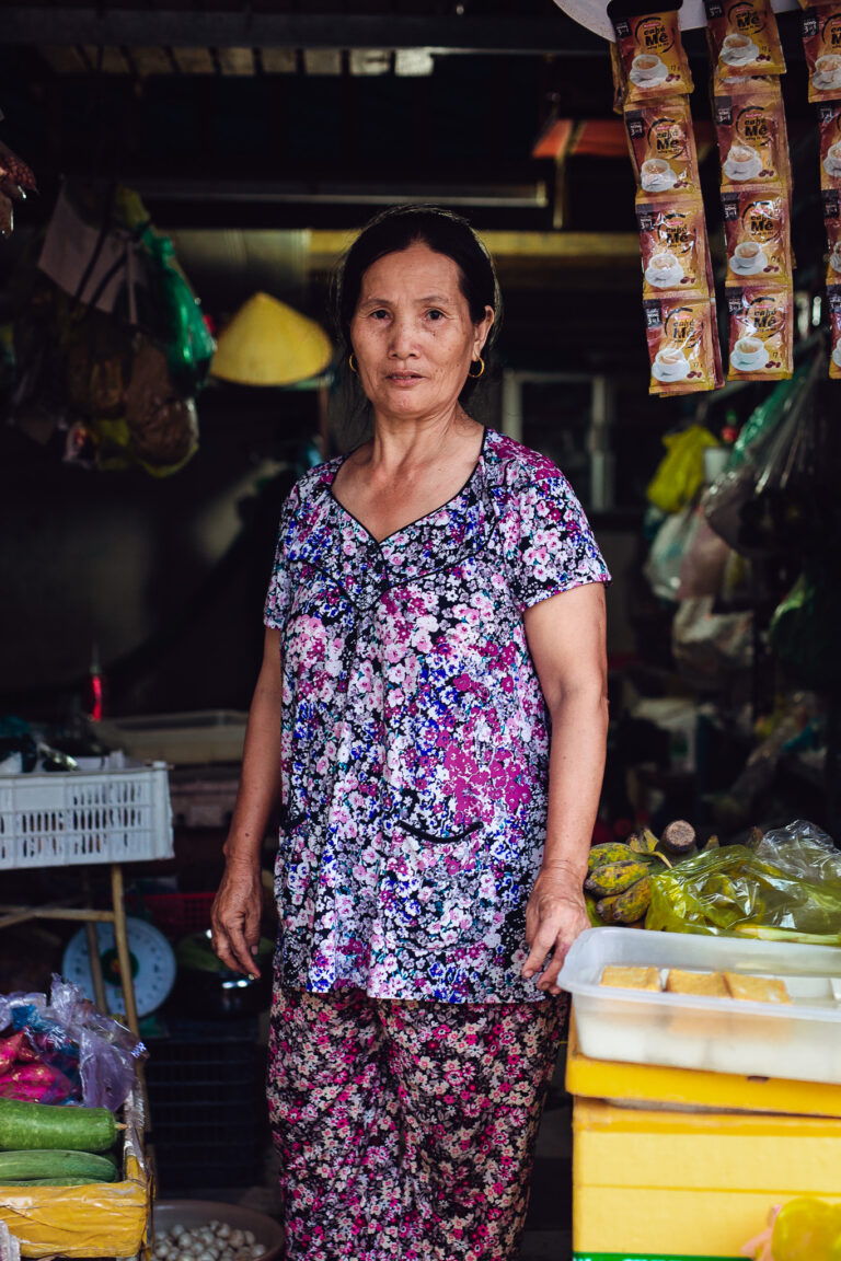 A Vietnamese woman poses for a portrait inside her local shop in Ho Chi Minh