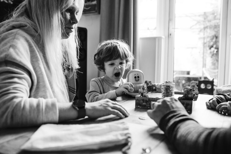 Leo shouting whilst playing a board game with his family during a family photo session.