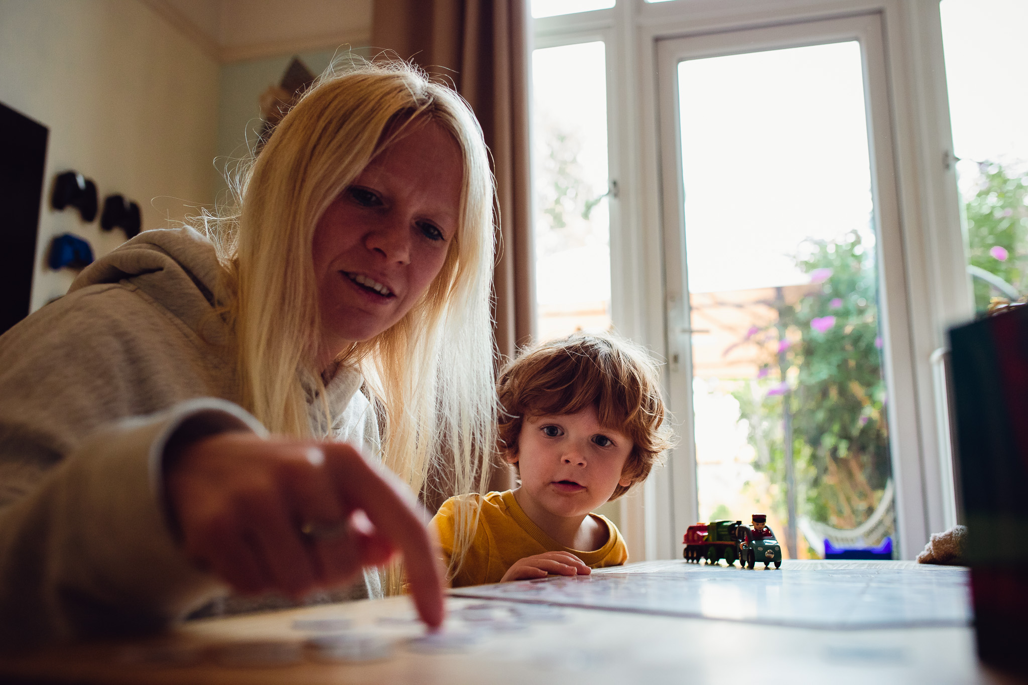 Mum pointing and showing something on a table to her son during a family photo session.