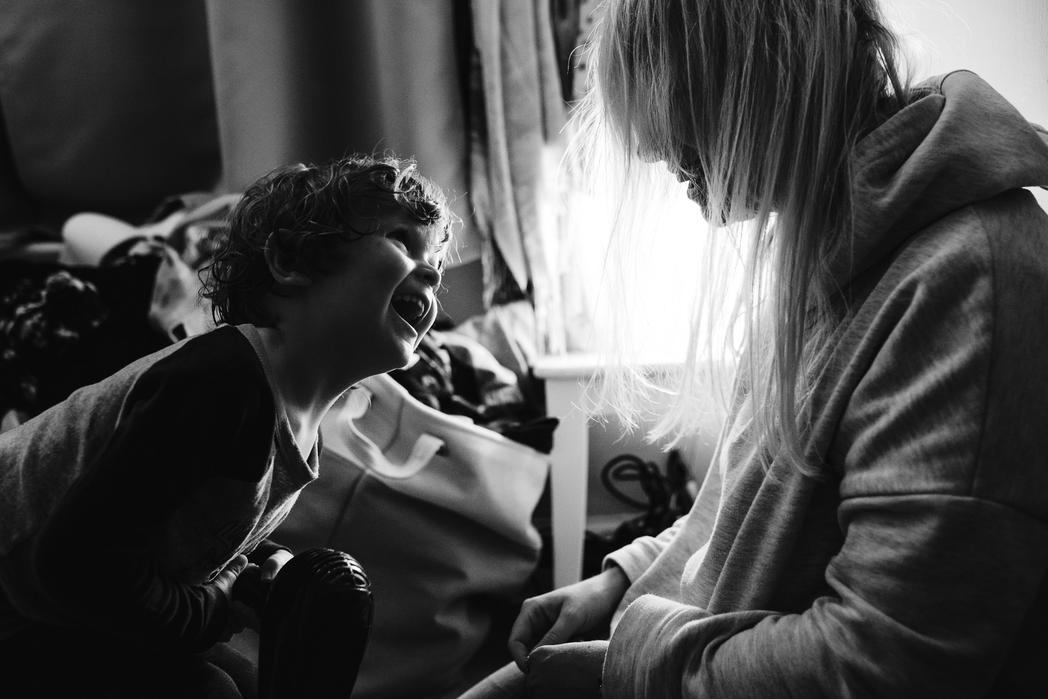 Mum and son laughing together whilst drying each others hair during a family photo session.