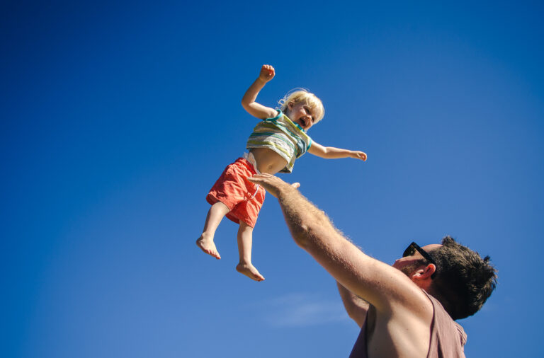 A toddler being thrown into the air by his dad