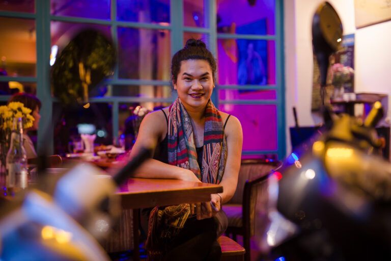 A transgender woman poses for a portrait whilst sitting outside a bar in Ho Chi Minh