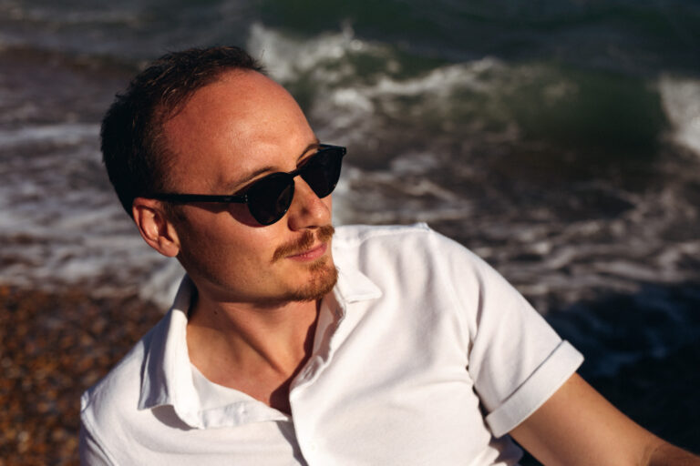 an outdoor headshot of a music producer down at Brighton beach
