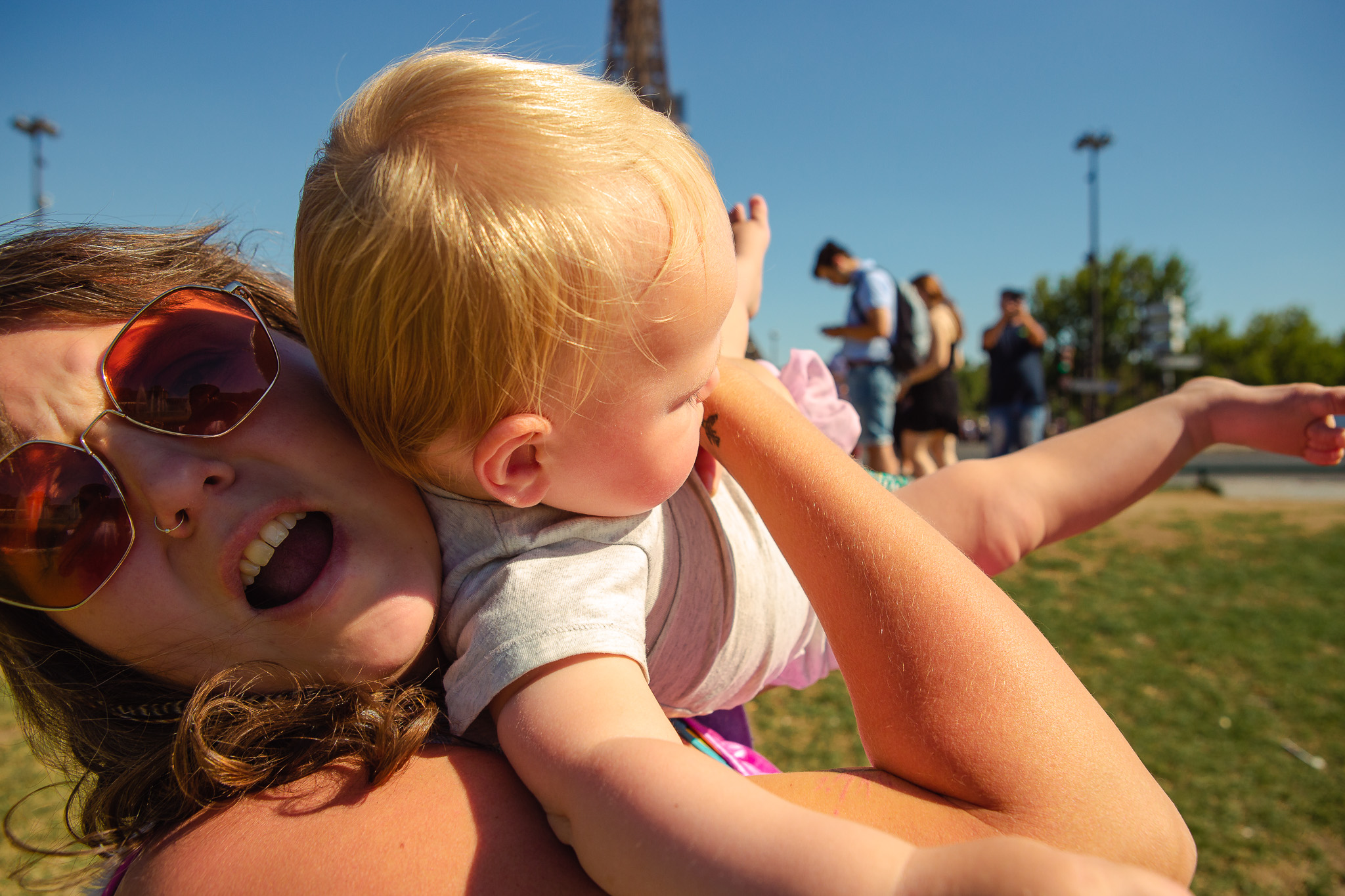 portrait of mum struggling with wriggling baby who's flinging himself into the air