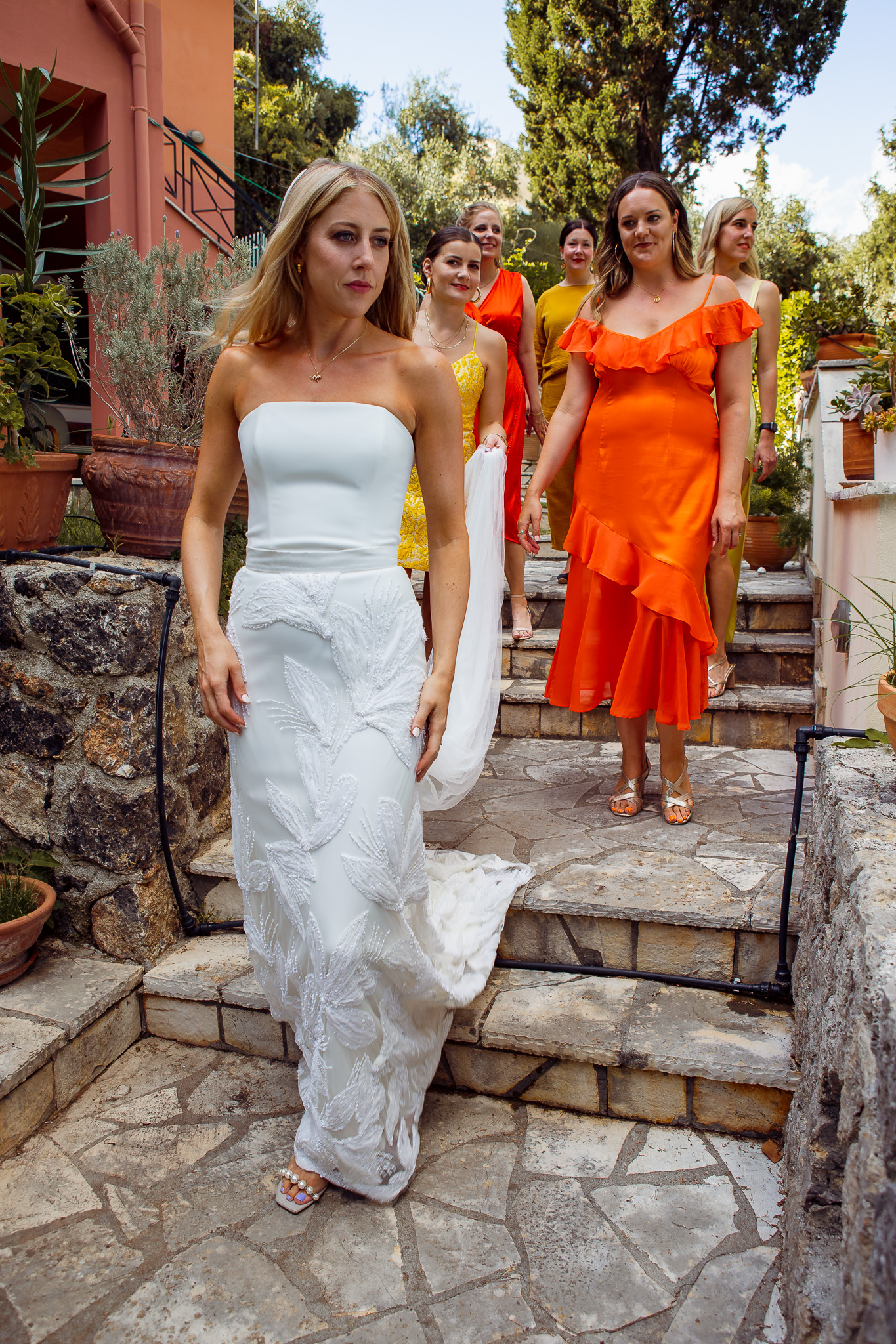 Alice and her bridesmaids walk down the steps of their villa in Crete.