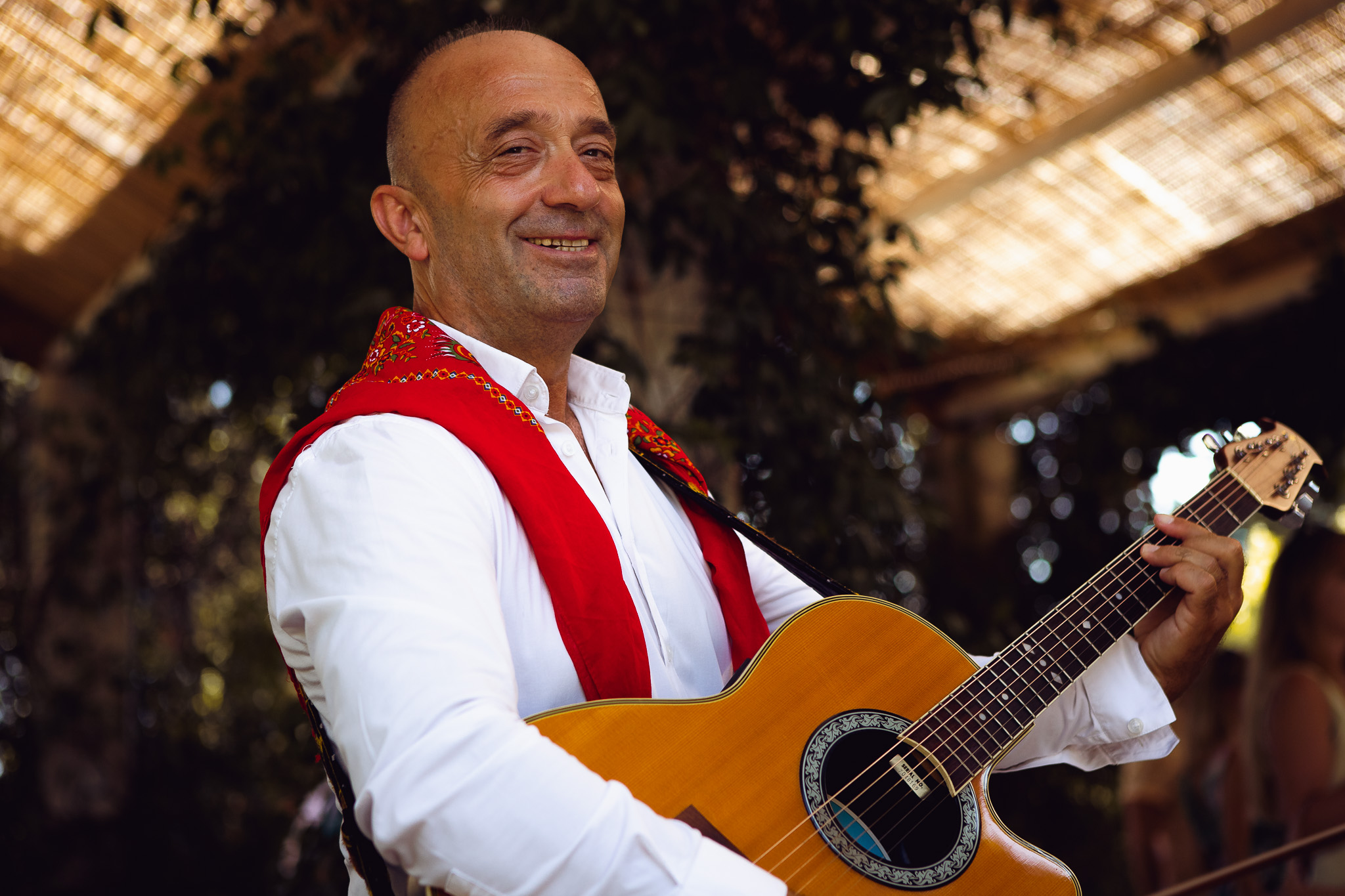 A guitarist from Alkinos Corfu Band smiles and plays at a wedding reception