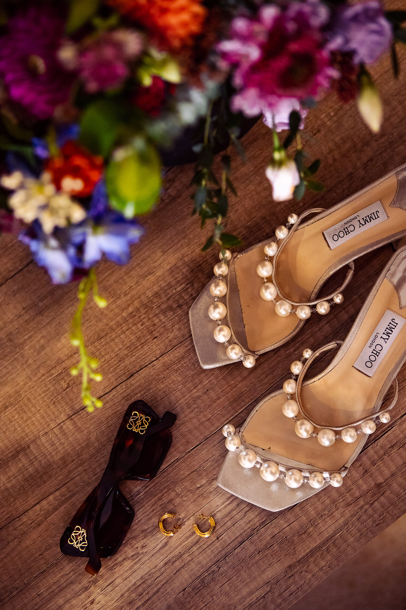 Jimmy Choo bridal shoes with wedding bouquet and accessories.