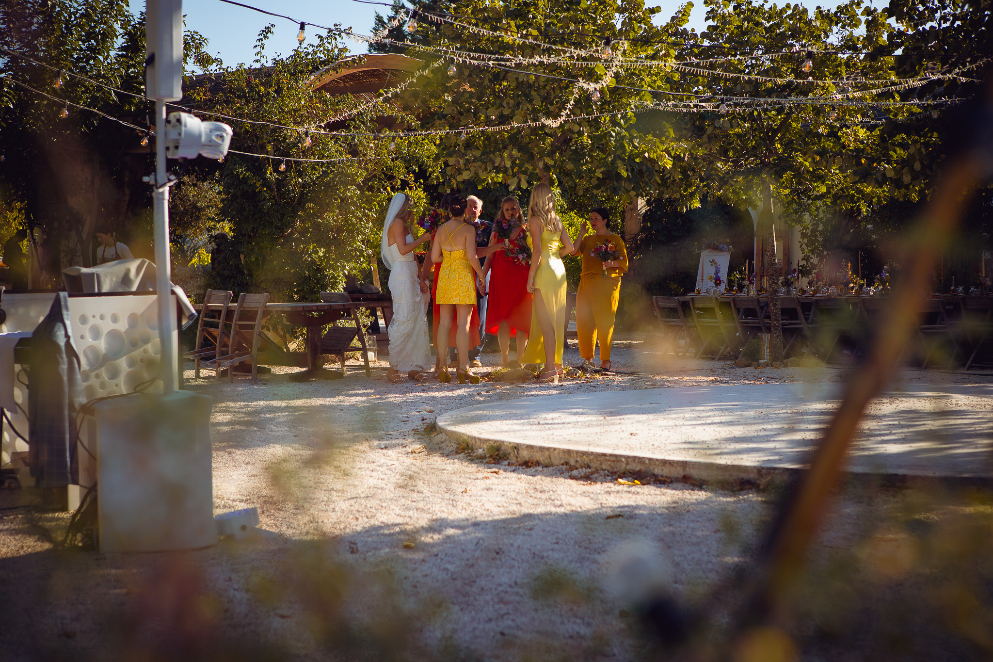 Bride and bridesmaids huddled under a tree before heading into the wedding ceremony at Ambelonas Vineyard, Corfu
