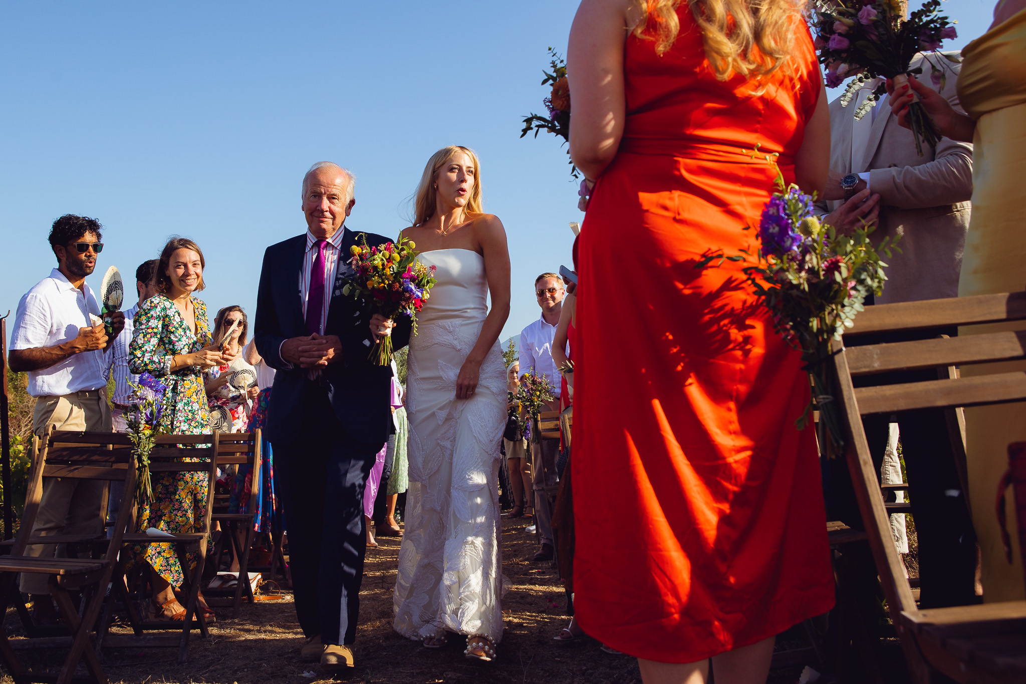 Bride walks down the aisle with her dad at a wedding ceremony in Ambelonas Vineyard, Corfu