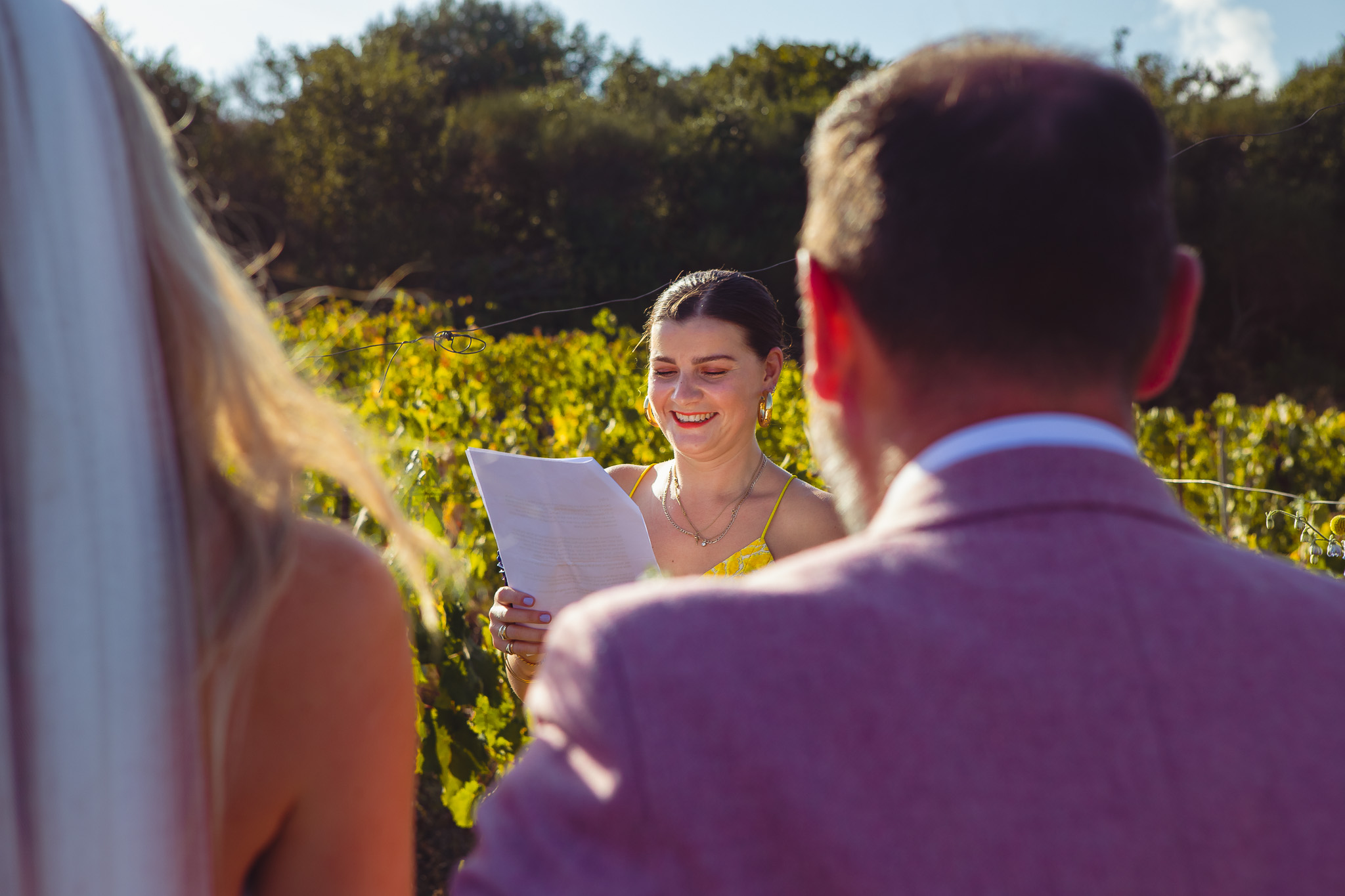 The celebrant smiles as she reads out to the bride and groom at their wedding ceremony