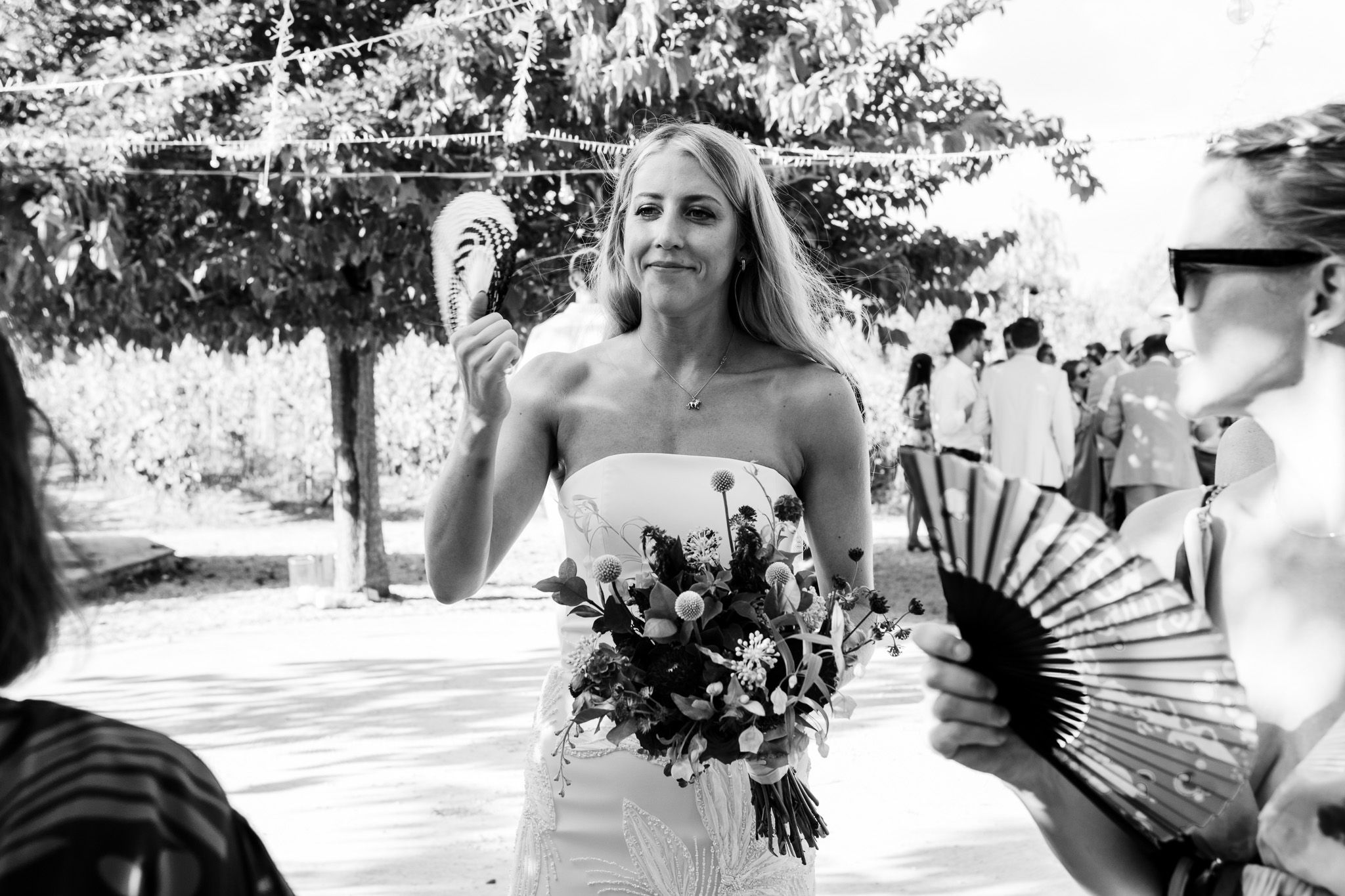 The bride smiles and fans herself at a very hot destination wedding in Corfu
