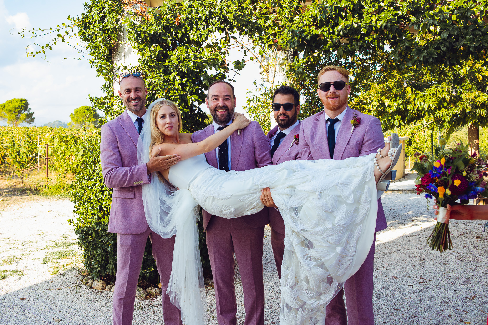The groom and his three best men hold the bride up at a destination wedding in Ambelonas Vineyard, Corfu