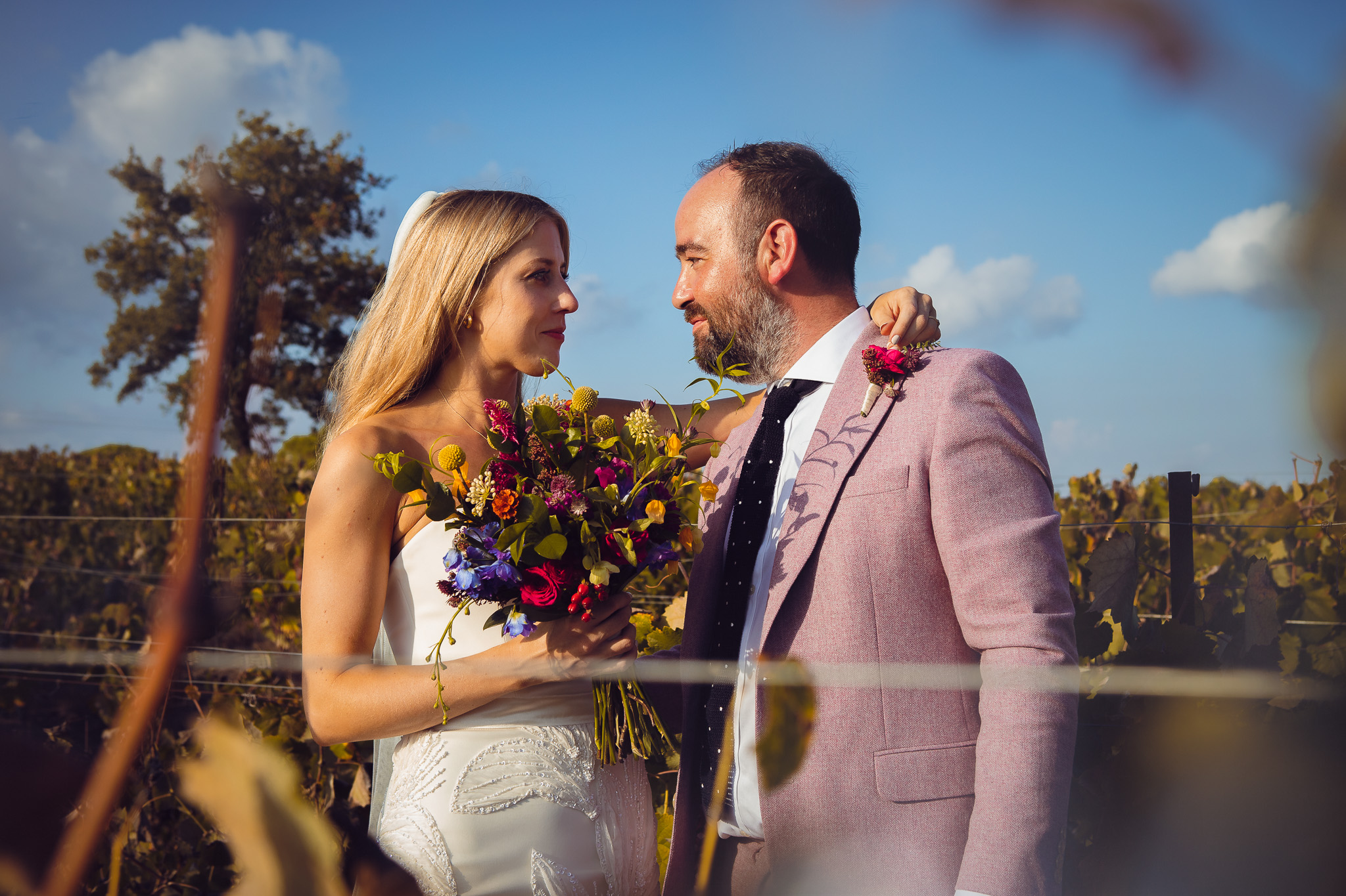 Alice and Tom look into each other's eyes during a couples photo session in the vineyard