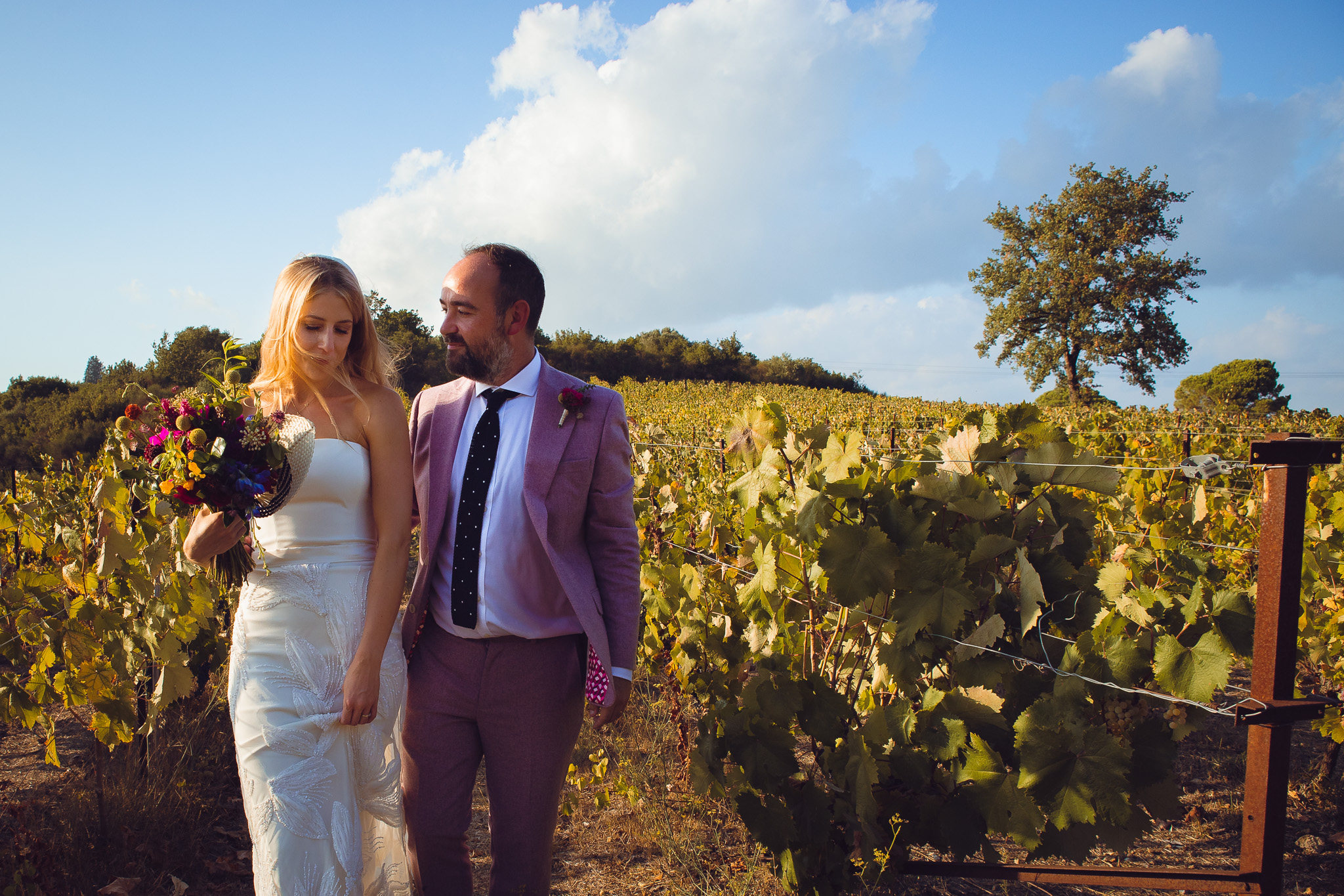 Alice and Tom walking through the vineyard at their destination wedding in Corfu
