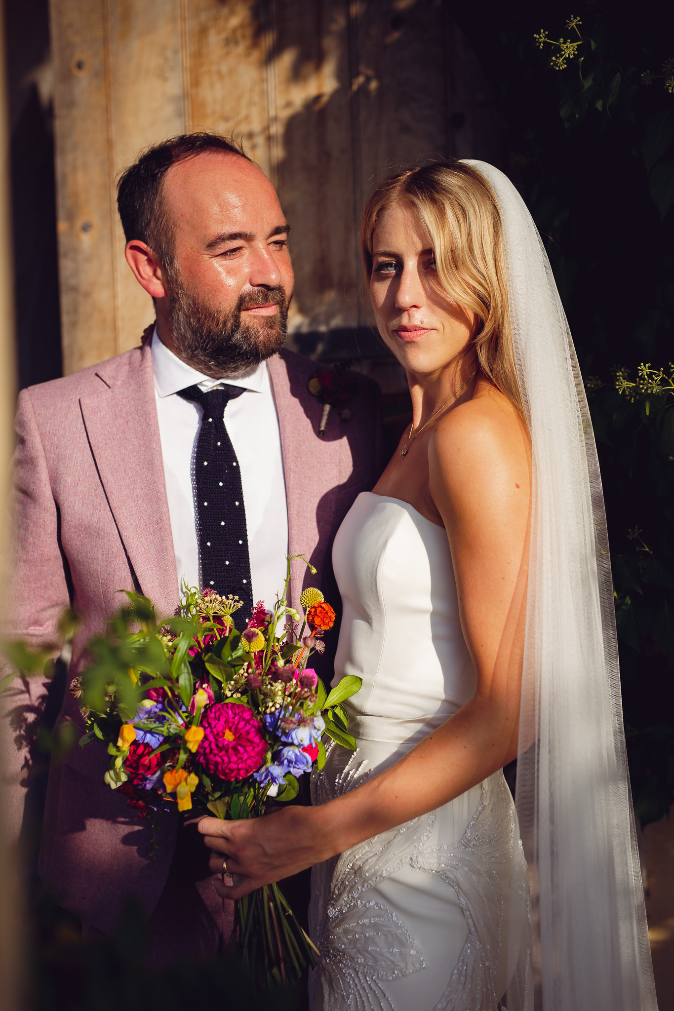 Tom looks at Alice whilst posing for a couples portrait