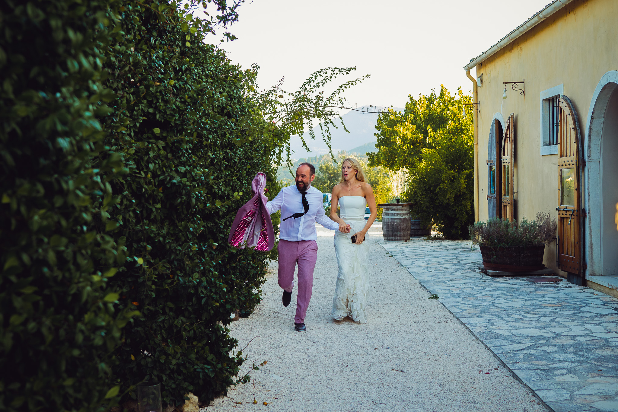 Alice and Tom run up together laughing at their destination wedding at Ambelonas Vineyard, Corfu