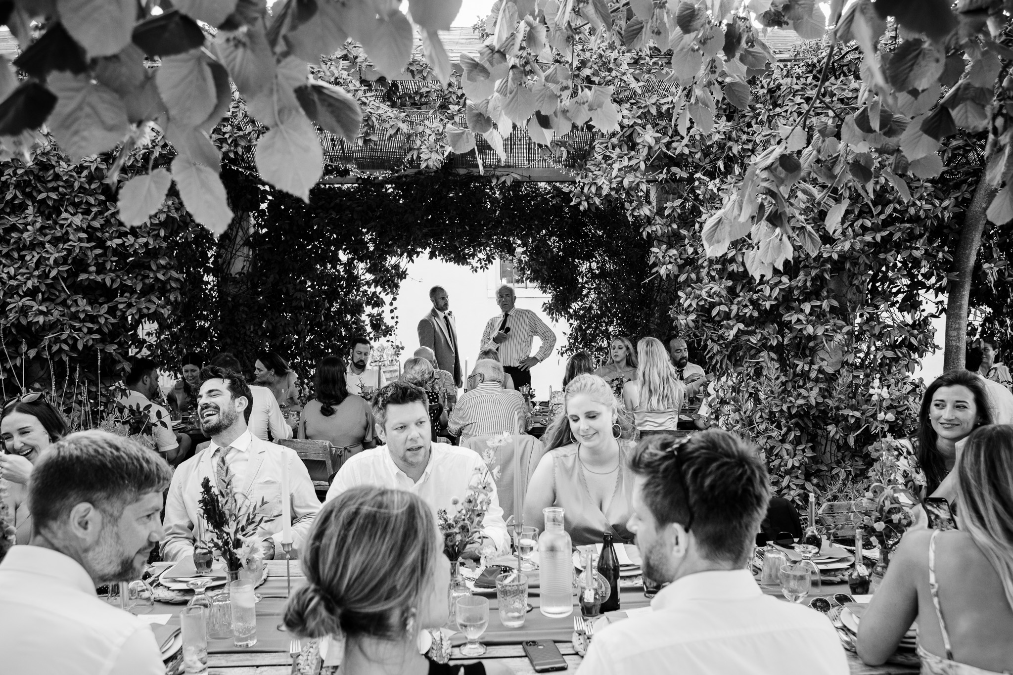 Guests chat and laugh as the father of the bride gets ready to do his speech at Ambelonas Vineyard, Corfu