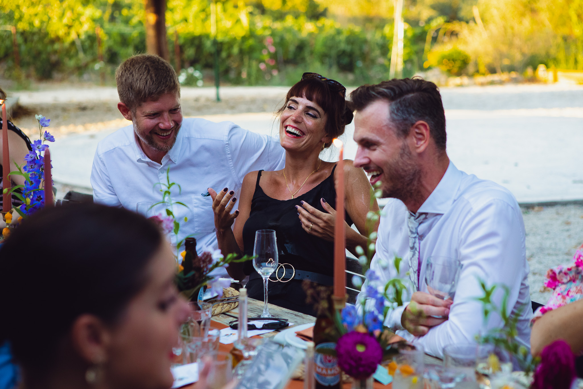 Guests laugh at the wedding dinner table at a beautiful destination wedding in Corfu
