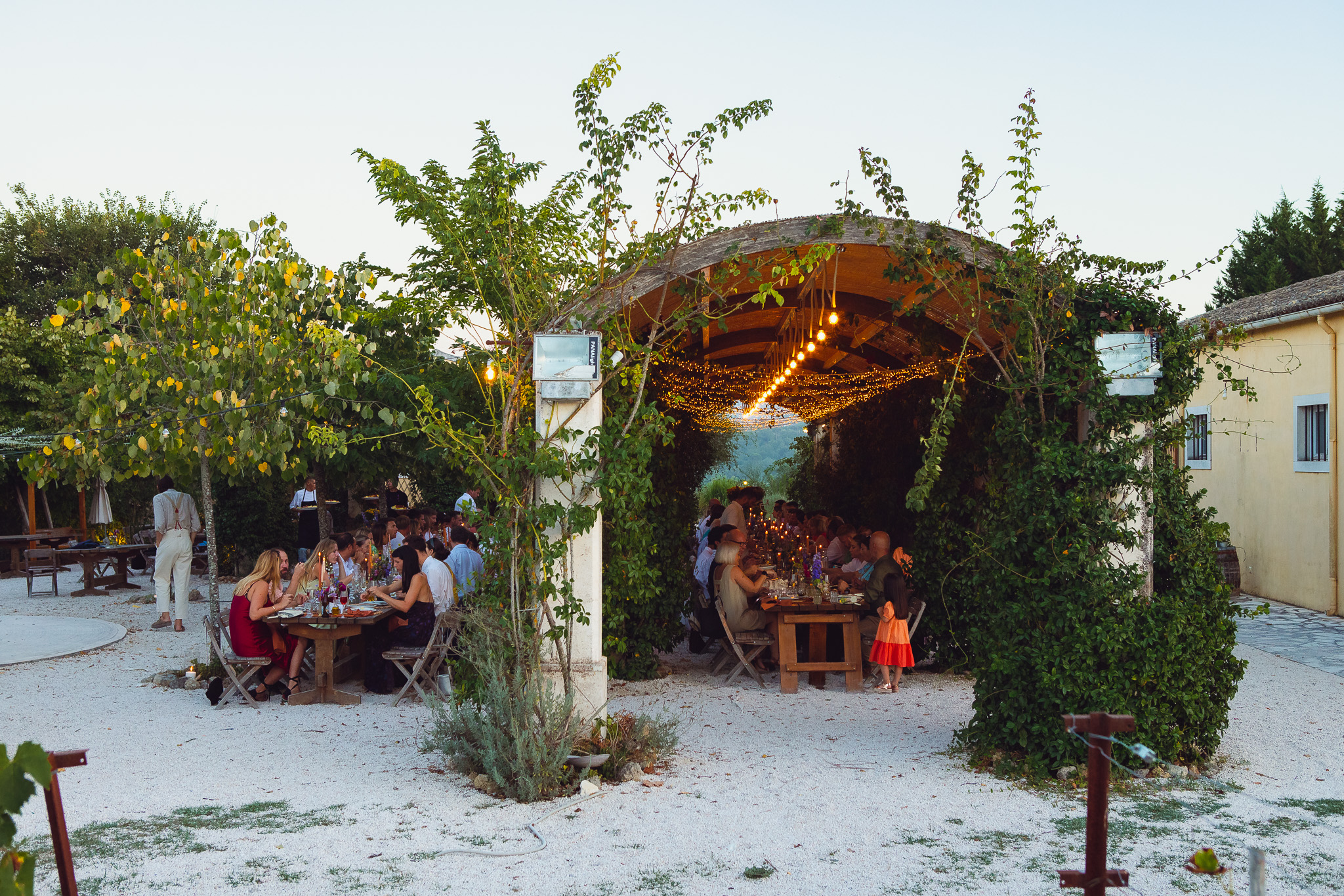 Guests sit and enjoy their dinner at a beautiful Greek destination wedding at Ambelonas Vineyard, Corfu