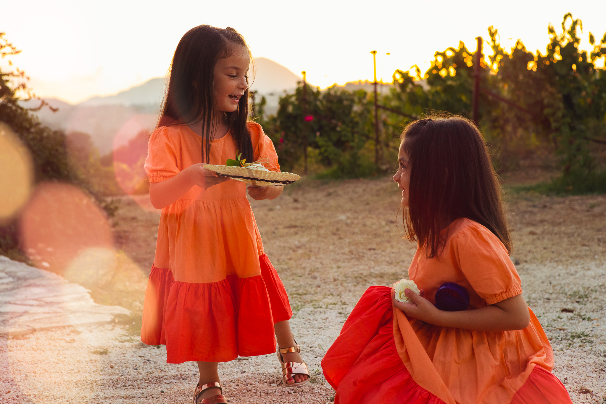 Two small girls play together at sunset at Ambelonas Vineyard, Corfu